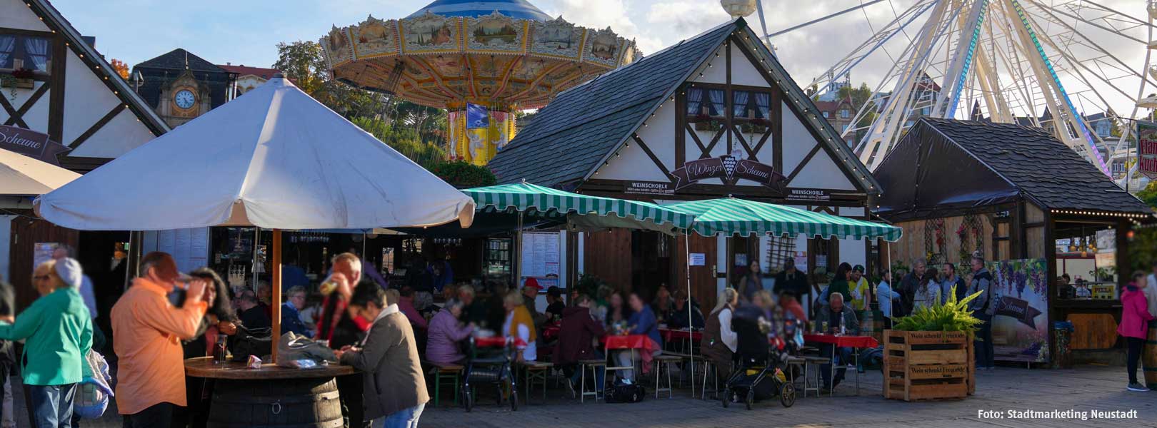 viele Personen, die gemütlich bei einem Weinfest  zusammensitzen